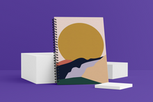 Load image into Gallery viewer, Golden Wellness Journal. The cover shows a large golden sun on the horizon with impressionist mountains in the foreground